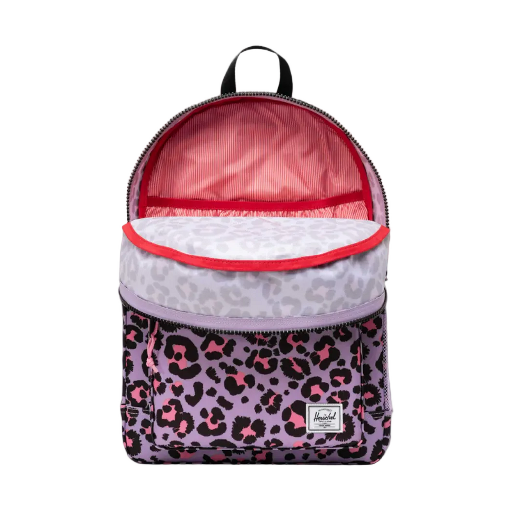 A Herschel backpack with a purple leopard print pattern, pink interior lining, and a light purple patterned top flap, shown open against a gray gradient background.