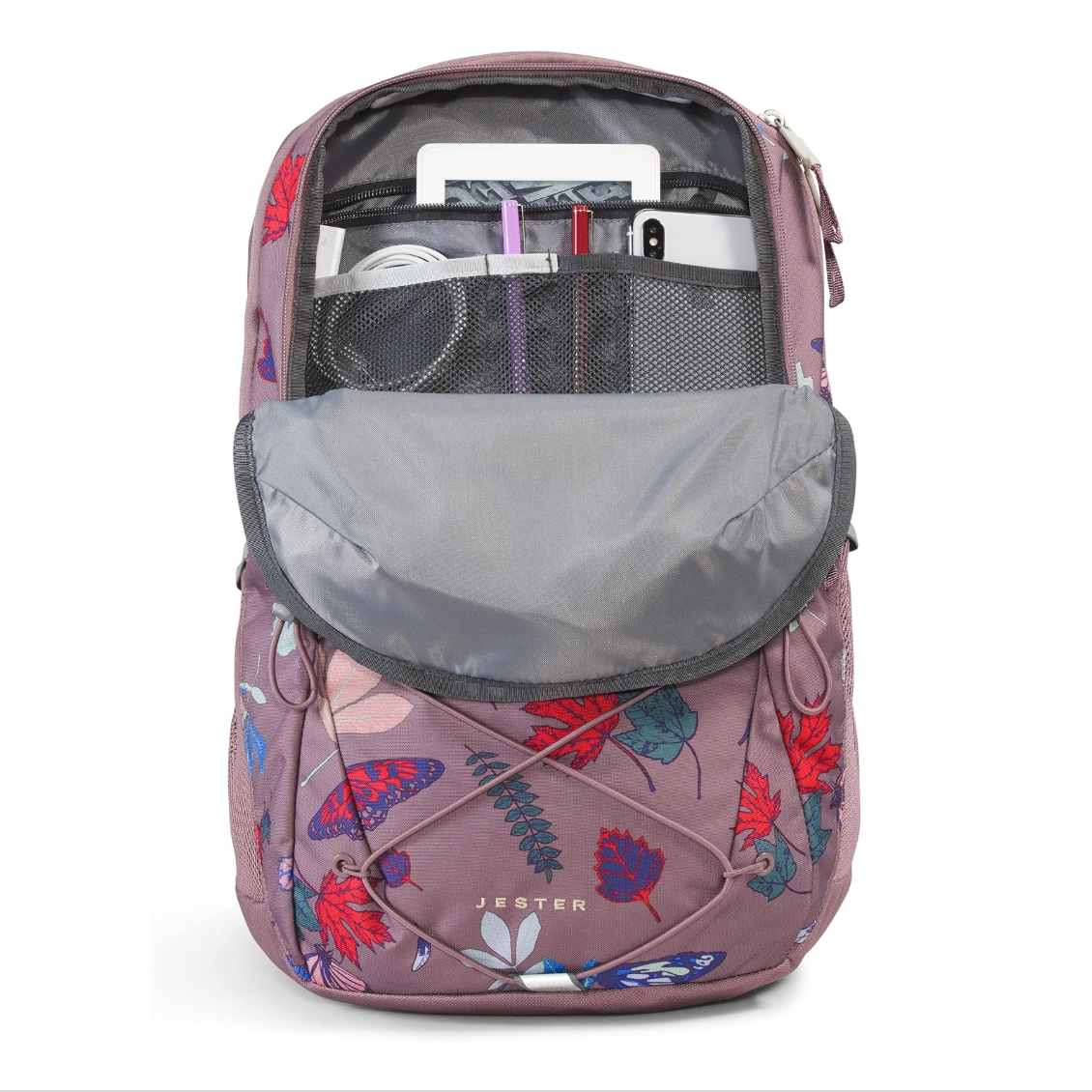 A Jester brand backpack in dusty pink with a colorful butterfly and floral print, shown open to display its interior compartments, mesh pockets, and laptop sleeve on a white background.