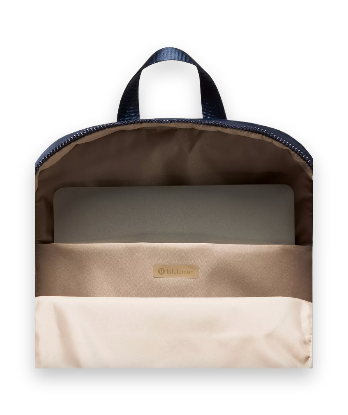 Open view of a Lululemon backpack showing the beige interior lining, a zippered compartment, a laptop inside, and a navy blue top handle against a light gray background.