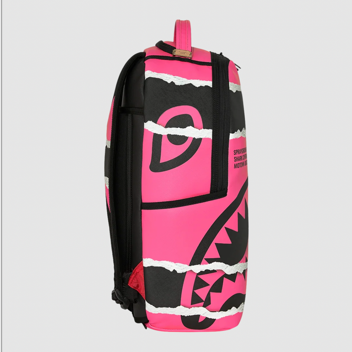 A backpack featuring a bold pink and black graphic design with torn-paper style white accents, shown against a neutral light gray background.